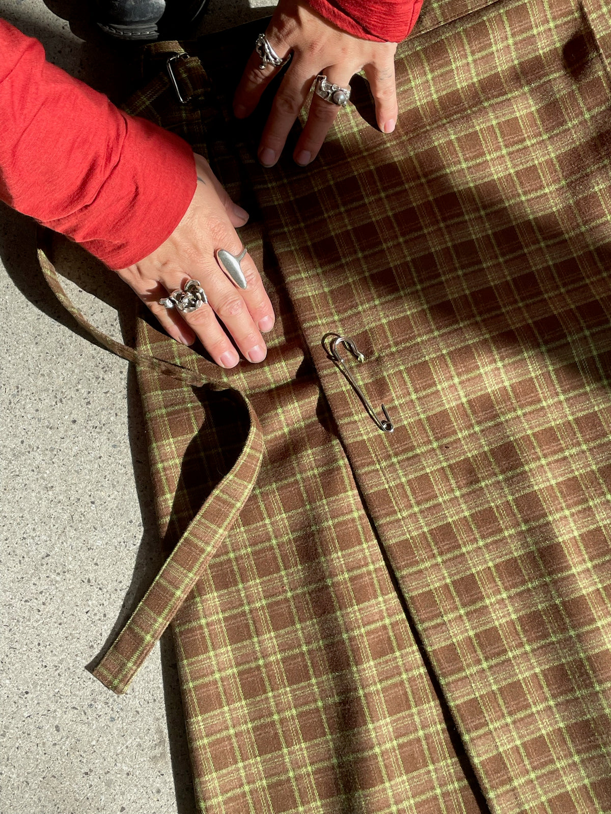 Two hands touching Pia skirt in Plaid Woodland